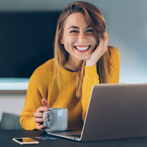 woman smiling while working on a laptop