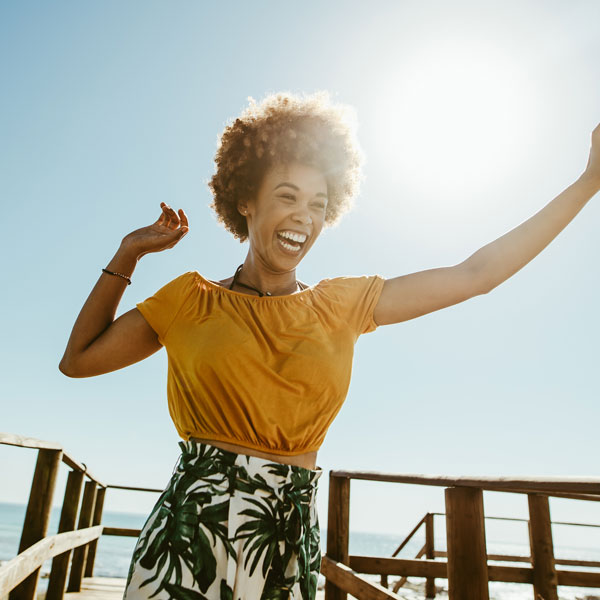 woman dancing and smiling outside